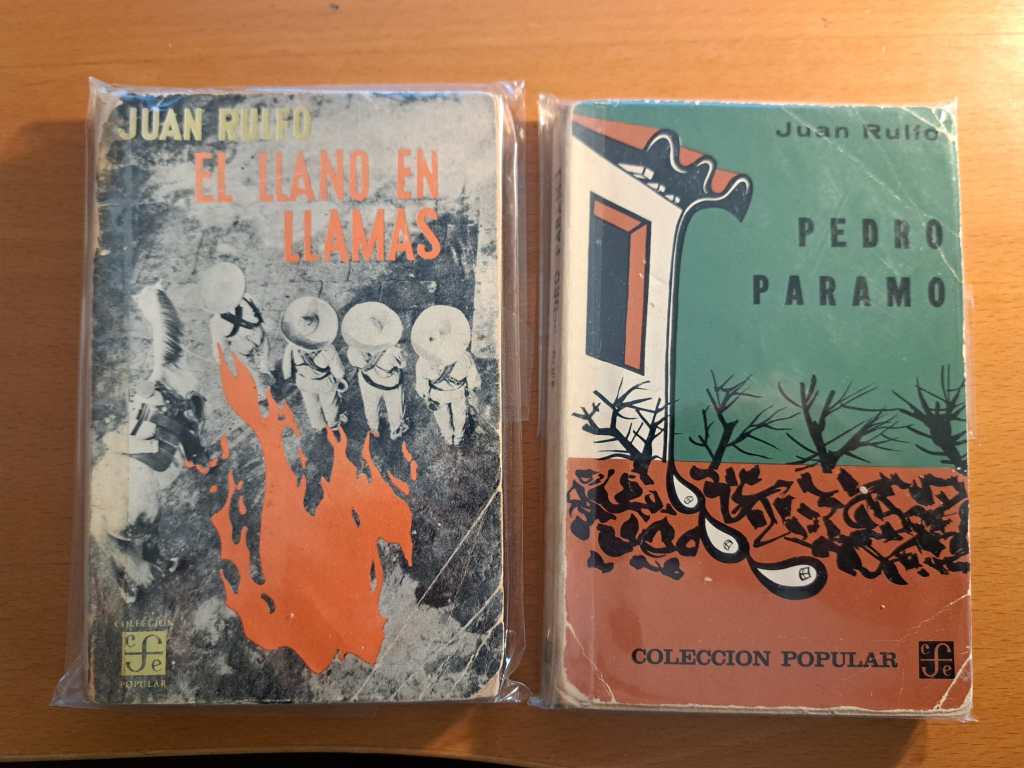 Photo of two paperbacks wrapped in plastic bags. Left, Juan Rulfo, El llano en llamas, right Juan Rulfo, Pedro Páramo, both Colección Popular, FCE, México. One is a fourth edition, the other a sixth edition. Both copies show signs of usage and time passing. 